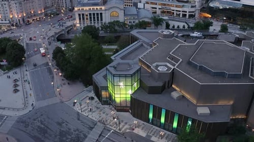 Ottawa's NAC at dusk with people and the senate building in the background