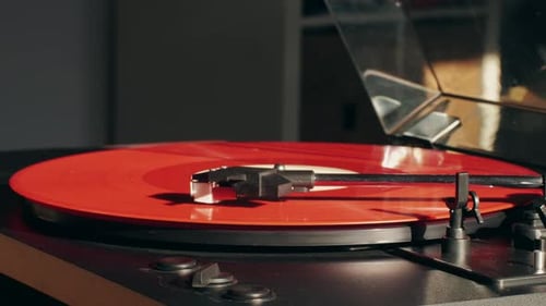 Red Vinyl Record Spinning on Turntable Close Up