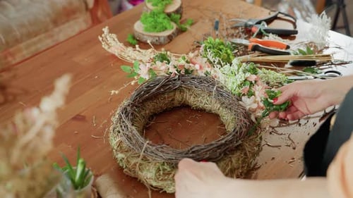 Woman's Hands Arranging Flowers in Spring Wreath