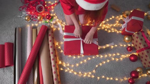 Woman Wrapping Christmas Present on Cozy Carpet