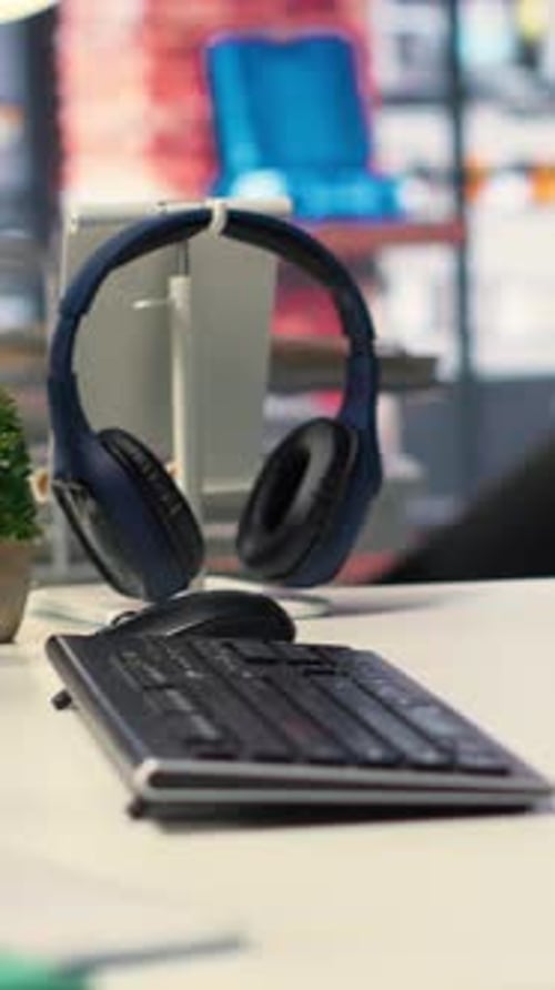 Headphones Hang Above Keyboard in Office Close Up