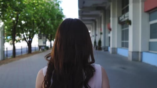 the Head of a Woman with Black Long Hair Who Walks Along the Street of Her City