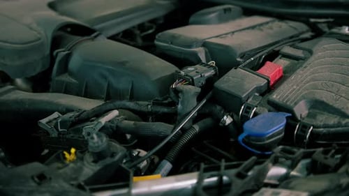 Vue rapprochée du vase d'expansion d'une voiture et du compartiment moteur d'une voiture de luxe bleue lors d'un entretien