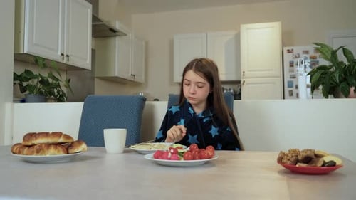 Girl Eating Breakfast at Table in Modern Kitchen