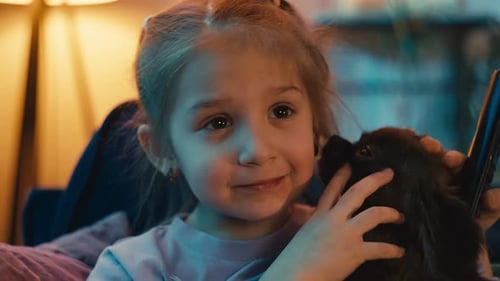 Young Girl Cuddling Dog Indoors