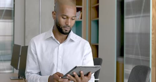 Portrait of African American male business executive using a digital tablet in an office