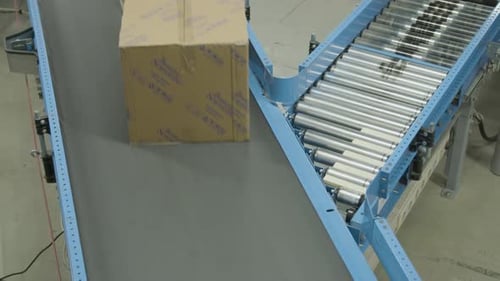 Packages Moving on Industrial Conveyor Belt in Warehouse
