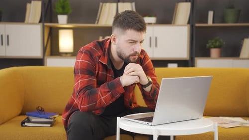 Man Working on Laptop Computer from Home
