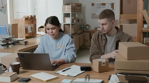 Storeroom Manager Scanning Barcodes on Parcels and Communicating with Colleague