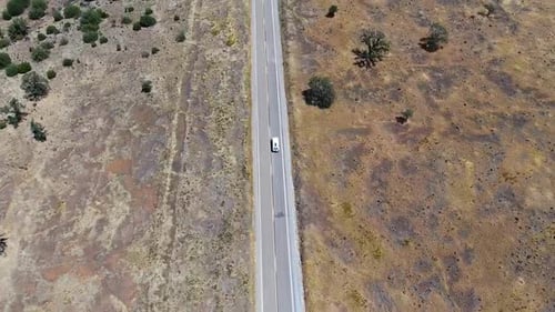 Drone video of a road driven by cars in the middle of Lassen National Forest.