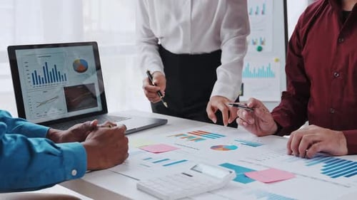 Business Team Collaborating Analyzing Financial Charts in Office