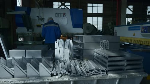 Factory worker with prefabricated metal parts