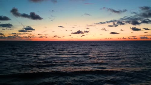 Tropical golden sunset over ocean water slow motion aerial view. Sun setting reflection on seascape.