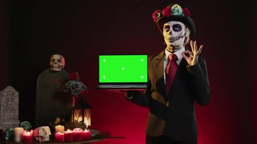 Modèle féminin effrayant tenant un ordinateur portable avec écran vert