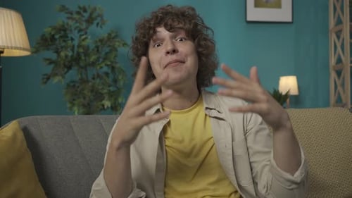 Friendly Man Talking and Gesturing on a Couch