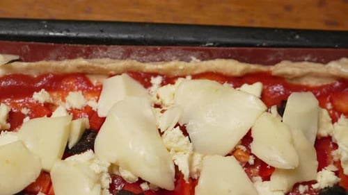 Pizza Toppings Hand Kitchen Adding Sliced Cheese to a Pizza in the Kitchen