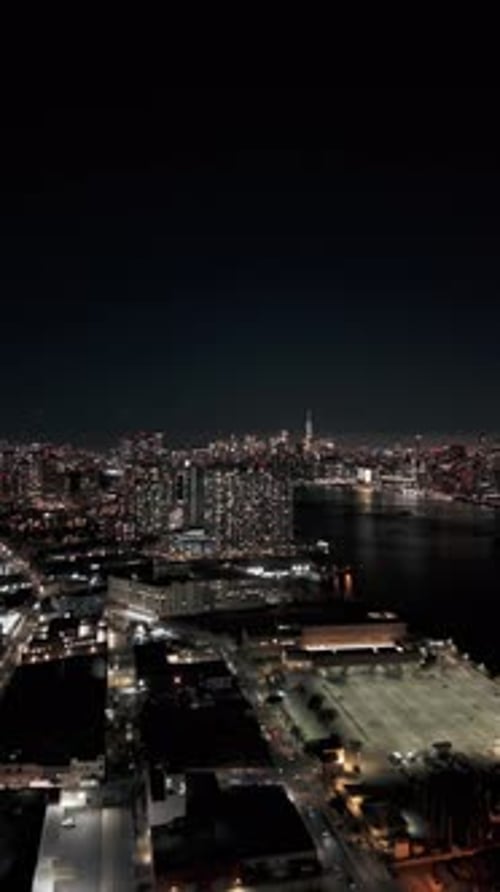 Camera Panning Upwards Revealing New York City Skyline at Night in a Vertical Video The East River