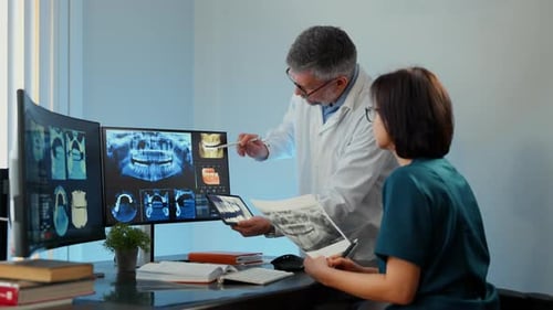Two Medical Professionals Reviewing Dental Xrays and Scans in Clinic Modern Healthcare Diagnostics