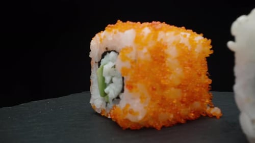 Three different rolls and chopsticks close-up, slide shot, rotation