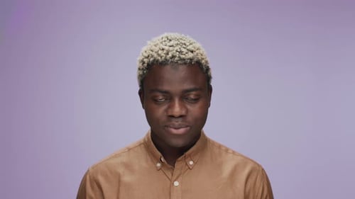 Smiling Man Poses Against Purple Background