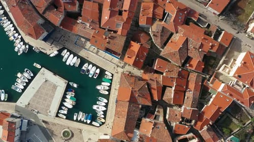 Aerial shot descending toward a marina on the island of Cres, Croatia on a bright day.