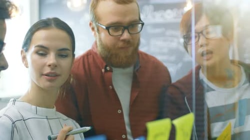 Diverse Team Collaborating on Sticky Notes in Office