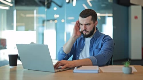 Man Works at Laptop Suffering from Headache