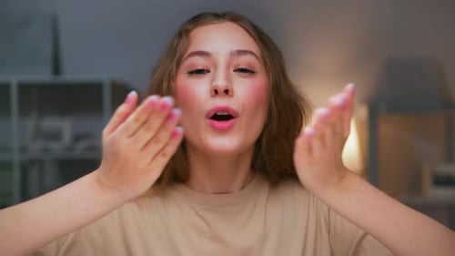 Young Woman Smiling and Blowing Kisses at Camera