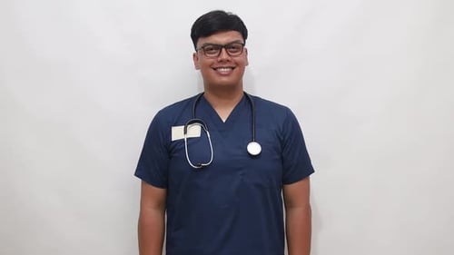 Médico asiático dando a mão para apertar a mão, médico de casaco azul olhando para a câmera e estendendo o chapéu