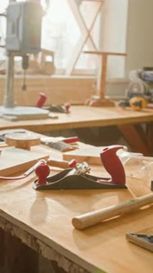 Vertical of Woodworking Tools on Cluttered Workbench in Sunlit Workshop