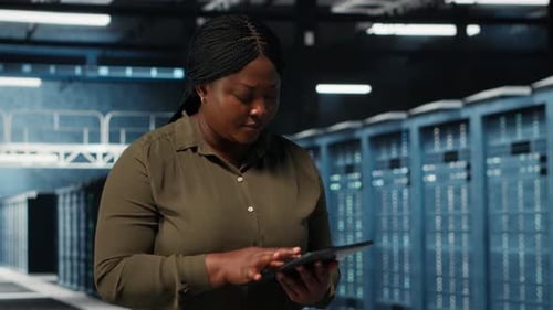Data Center Employee Uses Tablet to Manage Software Updates for System Stability