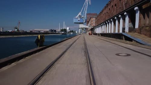 Drone flight at low altitude slightly angled in an harbour area with no people on a bright day in Ge