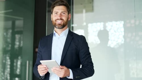 Smiling Businessman Holding Tablet in Modern Office