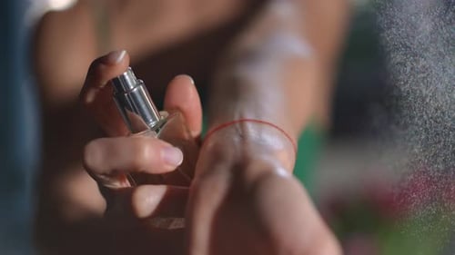 Woman Sprays Perfume on Wrist Close Up