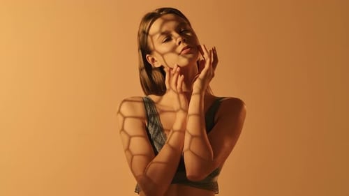 Elegant Woman Posing in Orange Light and Shadows