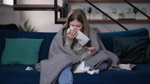 Sick Woman with Fever Resting on Couch