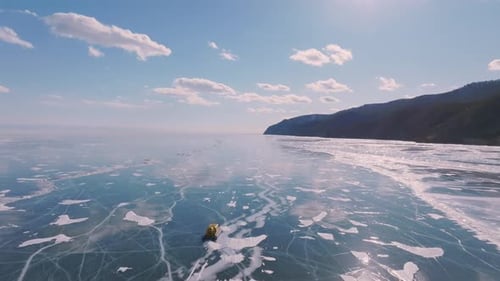 Hovercraft auf gefrorenem Baikalseeeis mit Rissen unter sonnigem Winterhimmel