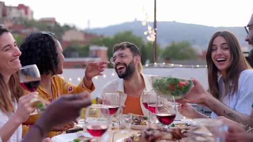 Diverse Happy Friends Having Dinner Party Outside at Rooftop Terrace