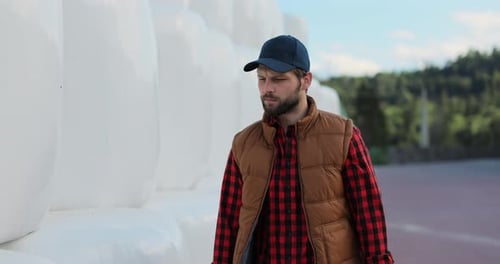 Close Up of Professional Agronomist Walking Hay Stack on Season Countryside