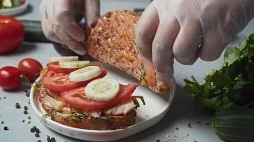 Hands Preparing an Open Face Sandwich With Vegetables