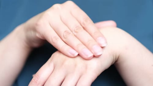 Frau, die Händedesinfektionsmittel an den Händen verwendet Die Wirkung des Reibens von Händedesinfektionsmittel an beiden Händen Bedeutung von