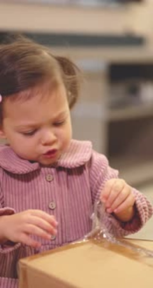 Girl Trying to Open Package Indoors