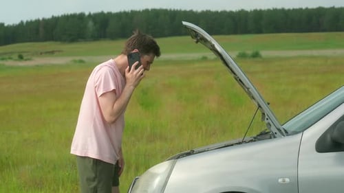 Man on Phone at Car with Open Hood
