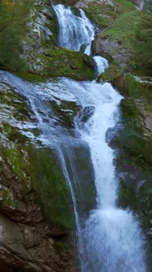 A Stunning Waterfall Cascading Down Beautiful Lush Green Rocks in Natures Paradise