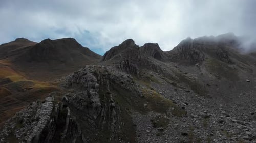 Pics des montagnes Rocheuses enveloppés de brume sous un ciel nuageux