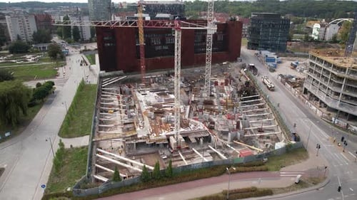 Toma aérea de un bullicioso sitio de construcción en un entorno urbano con edificios y carreteras circundantes.