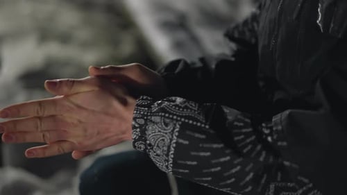 Hand View of Man Rubbing Hands to Stay Warm in Cold with Snow on Ground