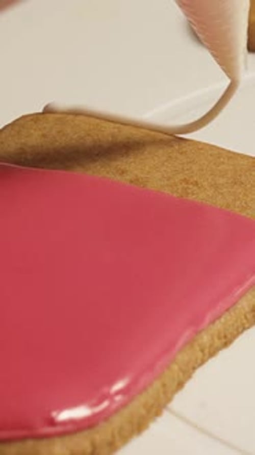 pastry chef decorates New Year's gingerbread cookies with colorful glaze Vertical video.