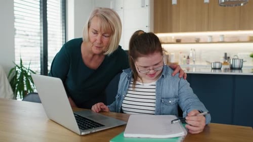 Senior Woman Helping Young Adult with Homework