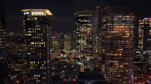 Illuminated Skyscrapers in Bustling City at Night